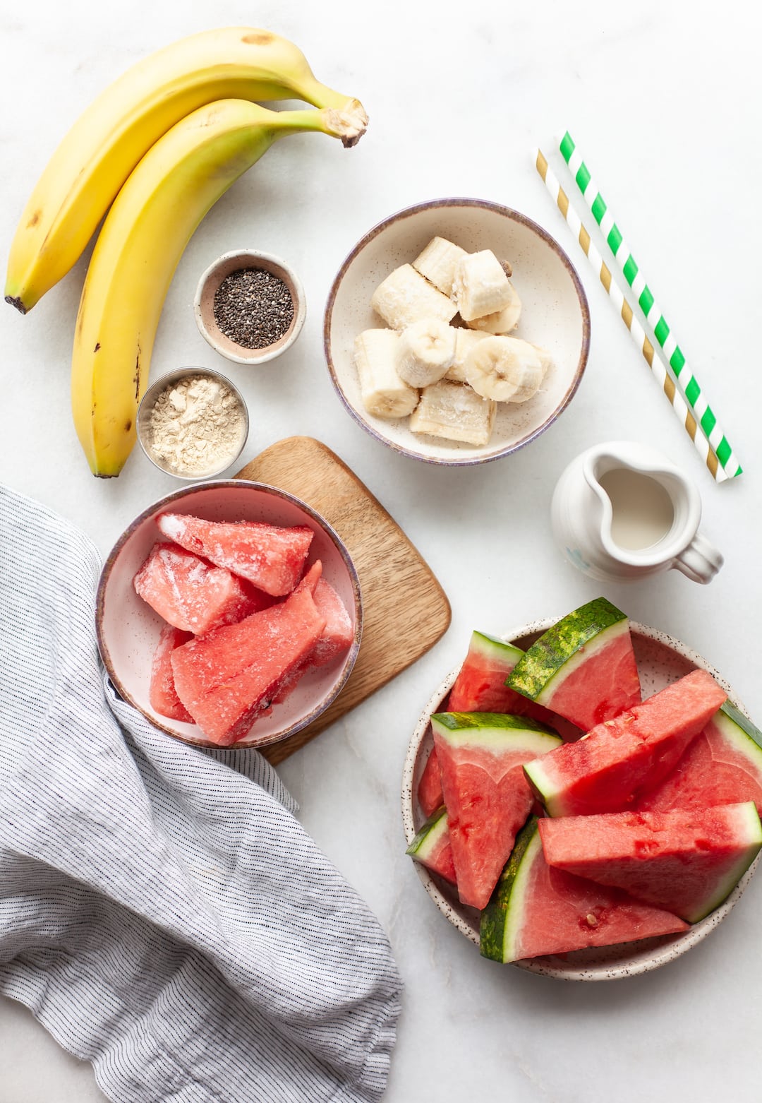ingredients for watermelon banana smoothie on a white marble board
