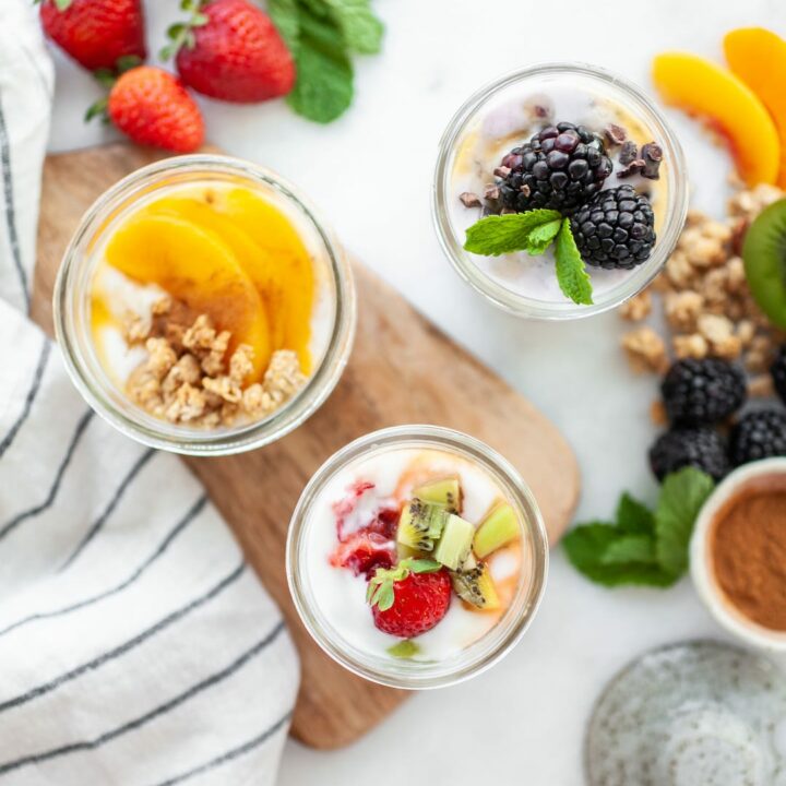 Overhead shot of 3 yogurt recipes in jars with fruit