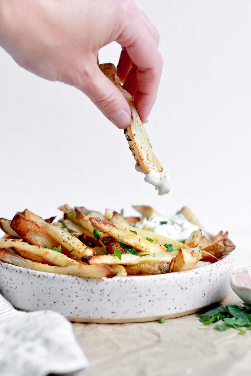 Dipping French fries that are homemade and healthy into herb aioli