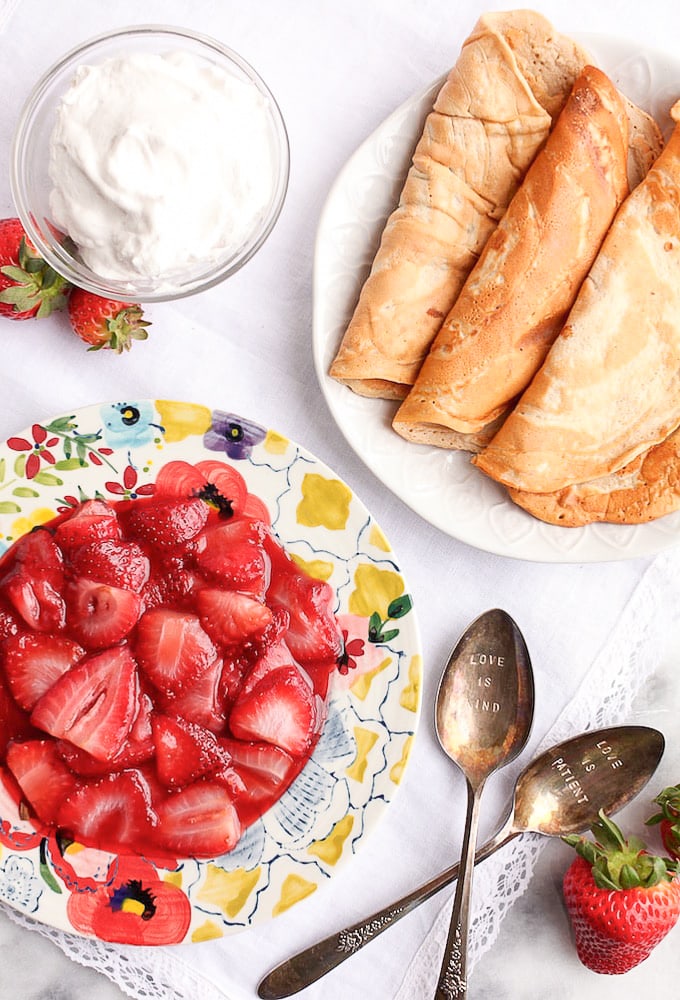 Healthy Protein Crepes on a plate with another plate with strawberry filling 