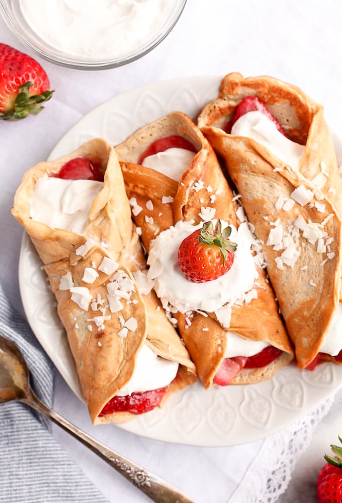 Healthy Protein Crepes on a plate topped with whipped cream and a strawberry