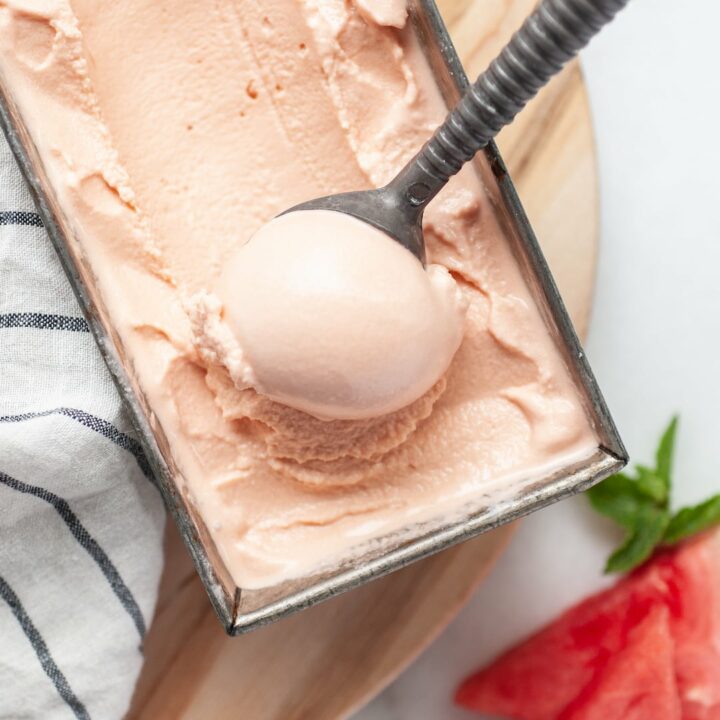 Watermelon Ice Cream being scooped out of a loaf pan with an ice cream scoop