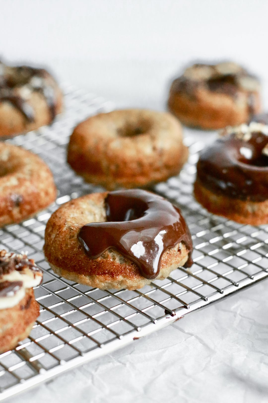 Naturally sweetened chocolate glaze pouring over a healthy banana bread donut