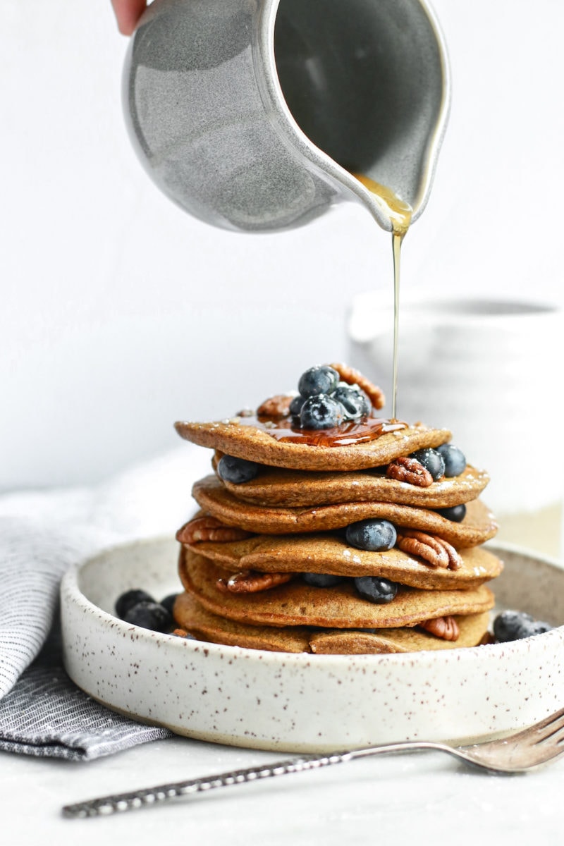 This delicious, simple, and healthy pumpkin spice pancakes recipe is gluten free, dairy free, vegetarian, and so easy to make. Made with rolled oats, and no sugar that's refined, these are full of fibre and great for fall mornings!