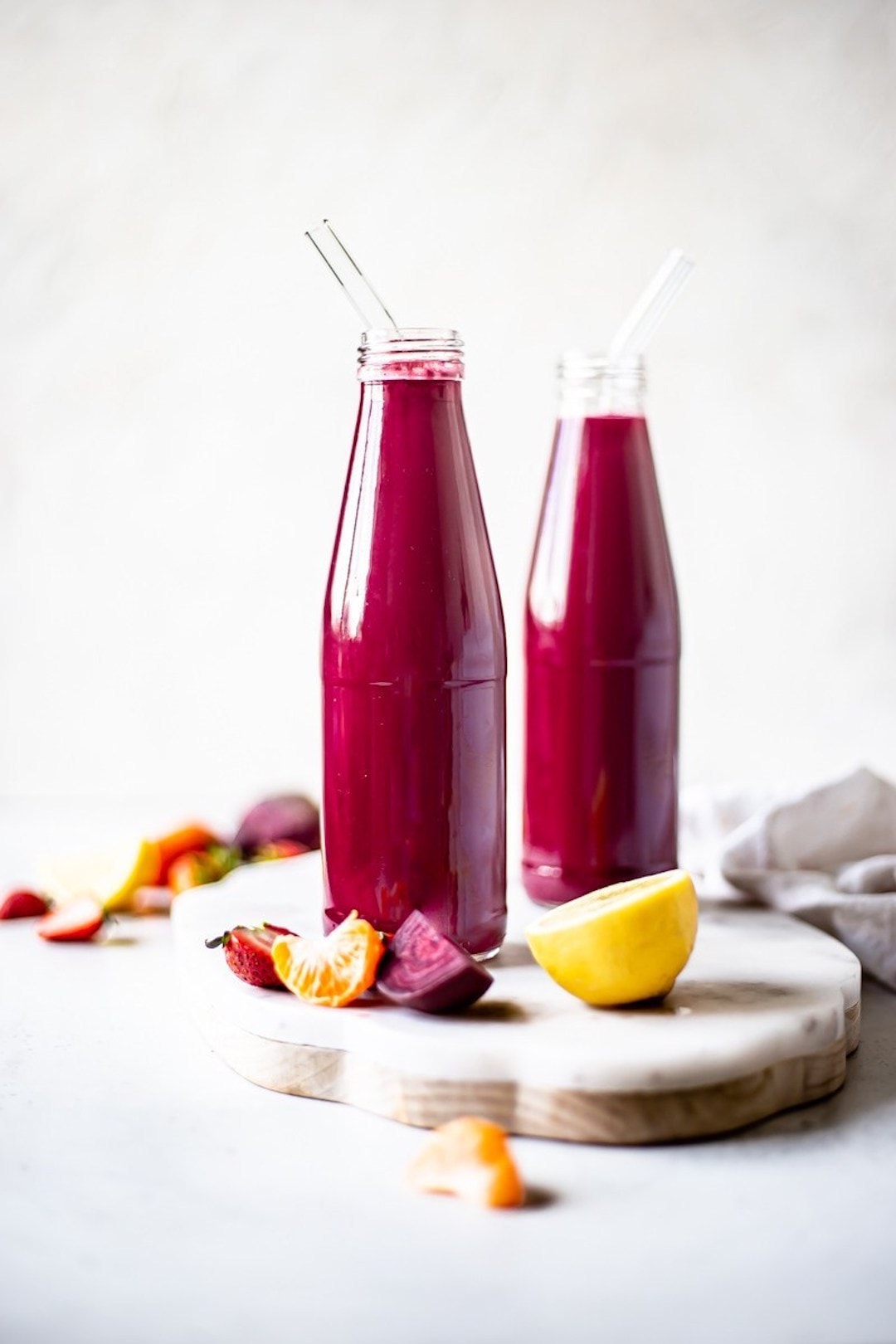 Two large jars with red beet juice and straws