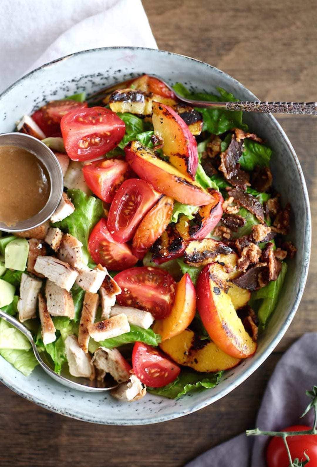 large bowl of salad with grilled chicken and nectarine