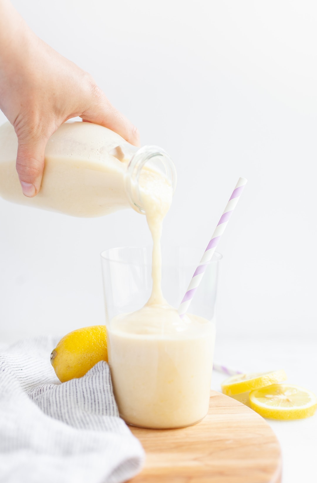 Pouring lemon banana peach smoothie into a glass