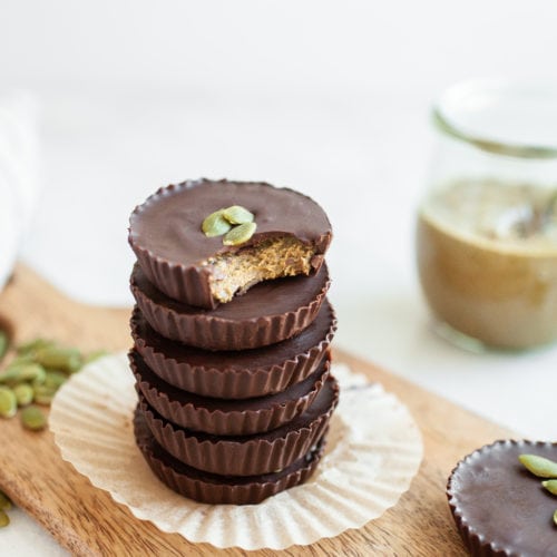 pumpkin seed butter cups in a stack with bite out
