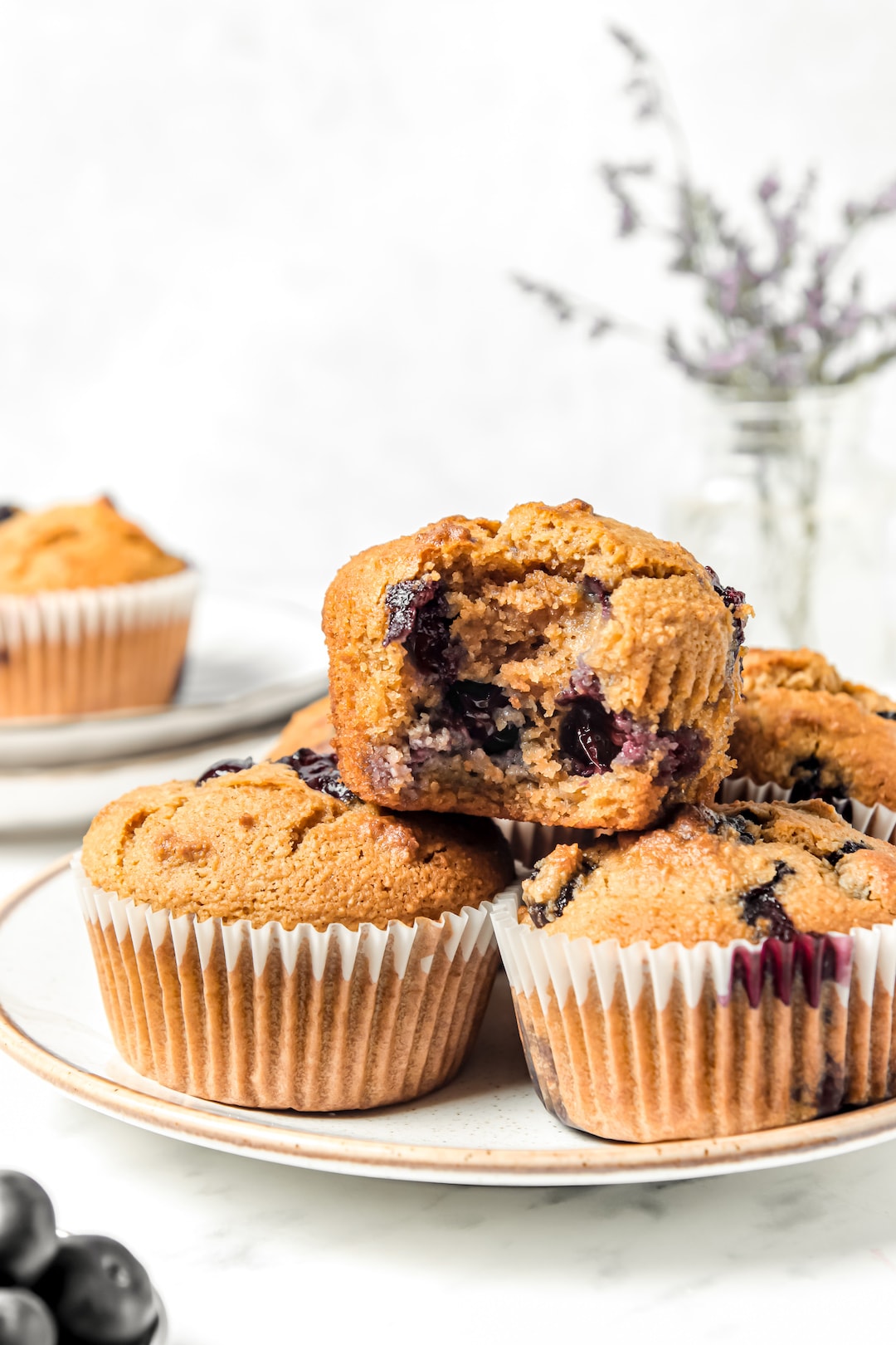 Close up of Fluffy Almond Flour Blueberry Muffins stacked on a plate