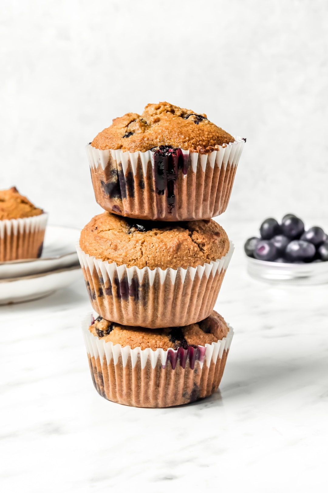 Three stacked Fluffy Almond Flour Blueberry Muffins
