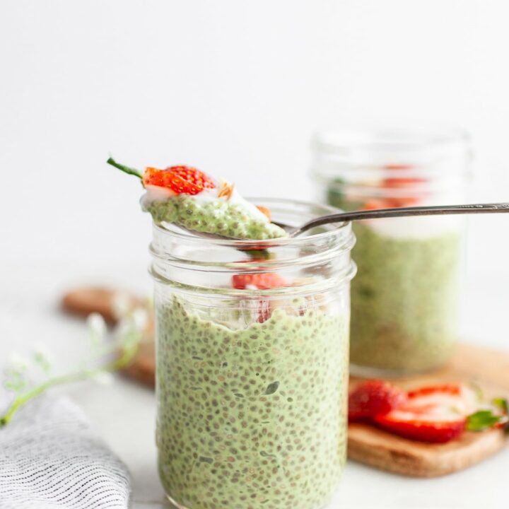 Spoon taking a scoop of Easy Matcha Chia Pudding out of a jar