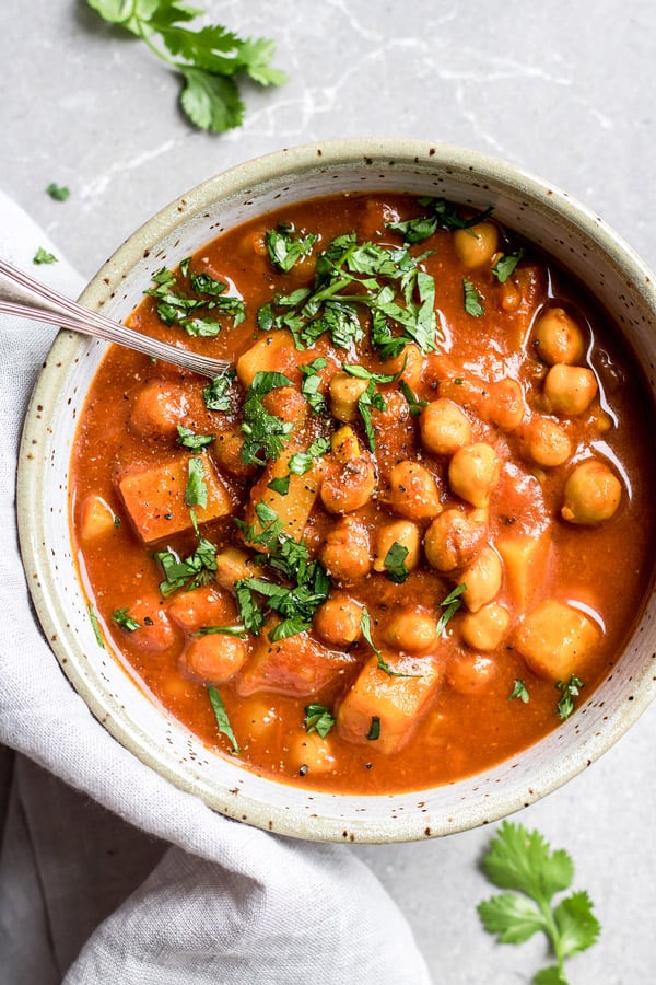 Colourful bowl of Moroccan chickpea stew garnished with fresh herbs