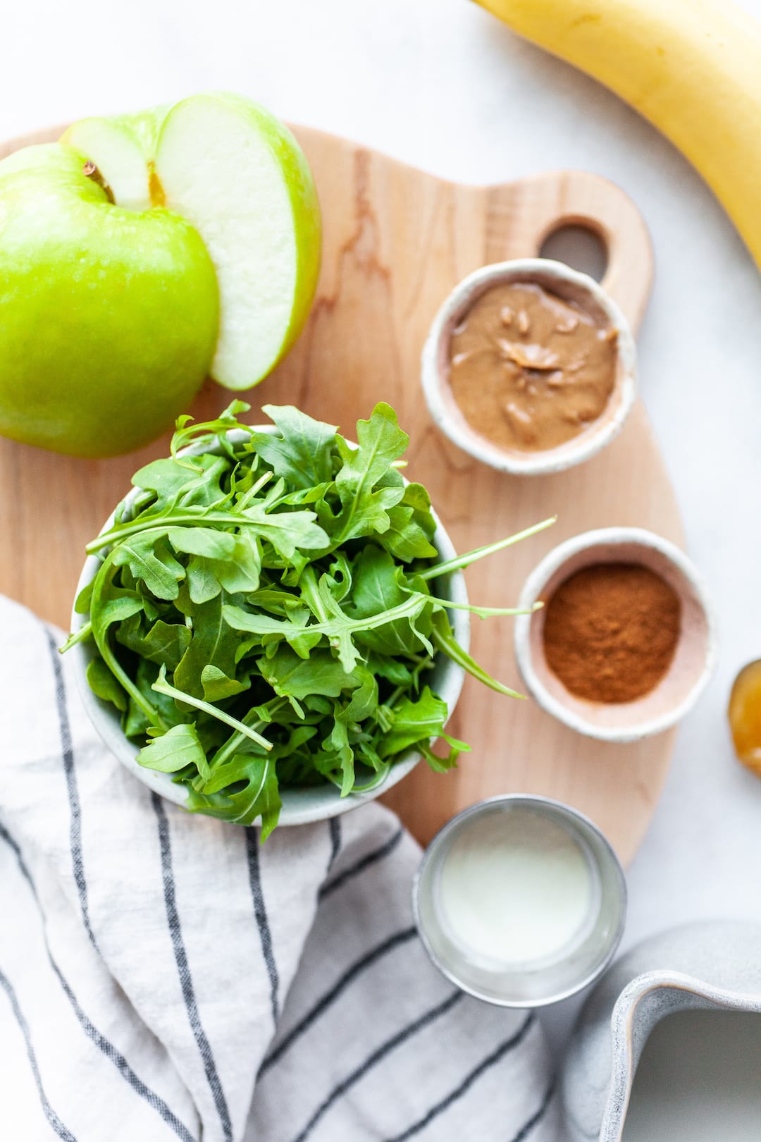 Ingredients for Delicious Arugula Smoothie Recipe spread out on a table