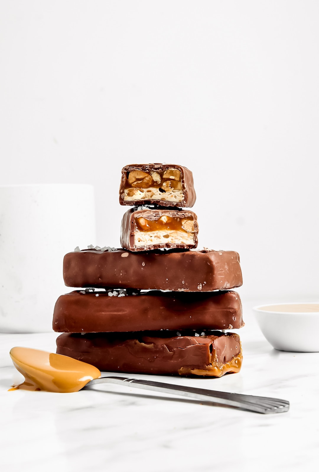 Must-Make Healthy 'Snickers' Protein Bars stacked with a white backdrop