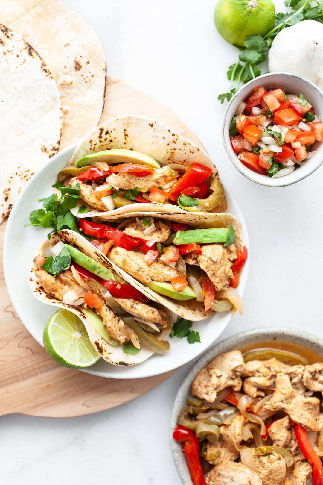 Instant Pot Chicken Fajitas on a plate with fresh salsa, avocado, and lime