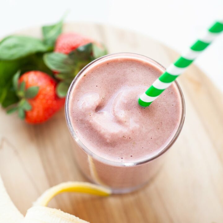 Easy Strawberry Banana Spinach Smoothie in a glass with a green straw