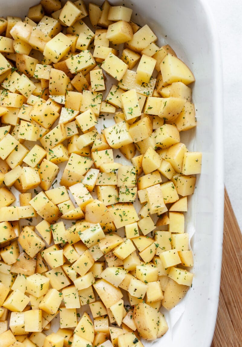 Raw potatoes in a baking dish for Dairy Free Breakfast Casserole
