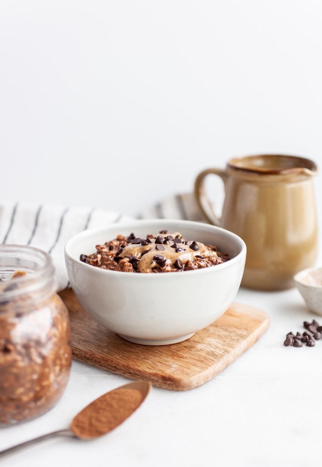 Healthy Chocolate Overnight Oats in a white bowl on a wood tray