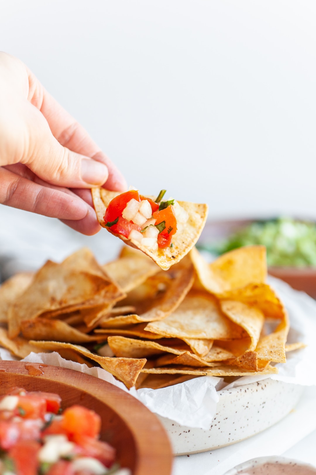 Scooping salsa with air fryer tortilla chips