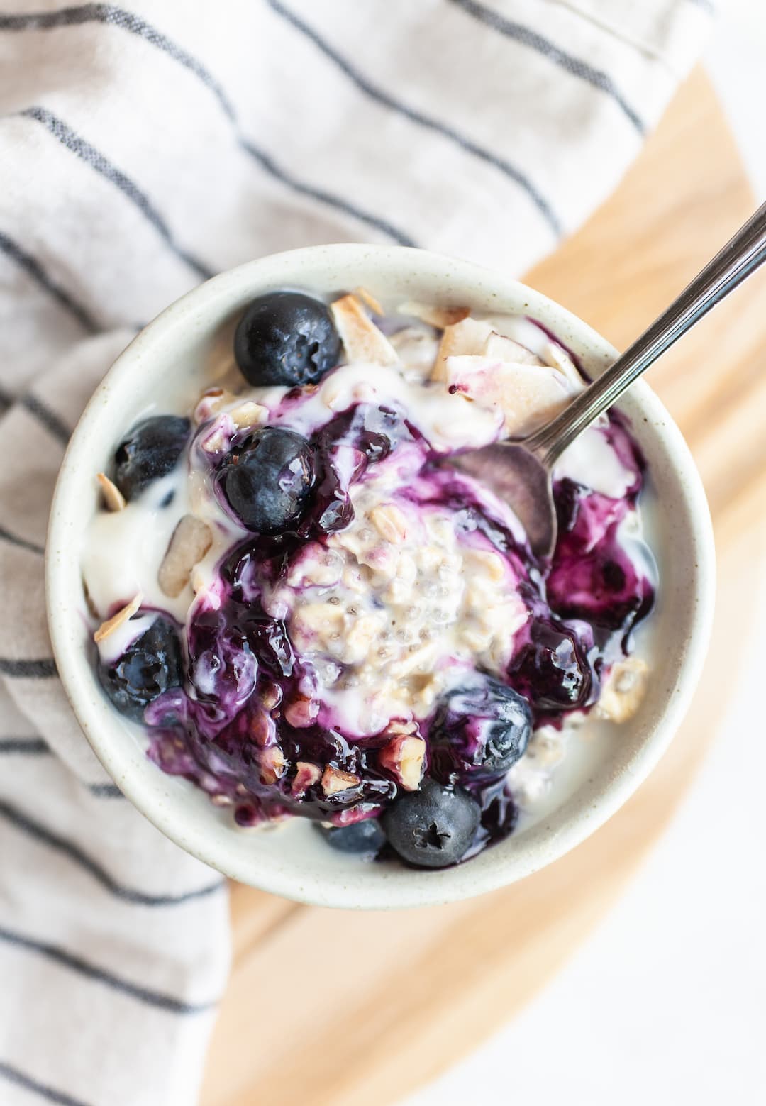 blueberry overnight oats in a bowl with blueberry sauce and yogurt