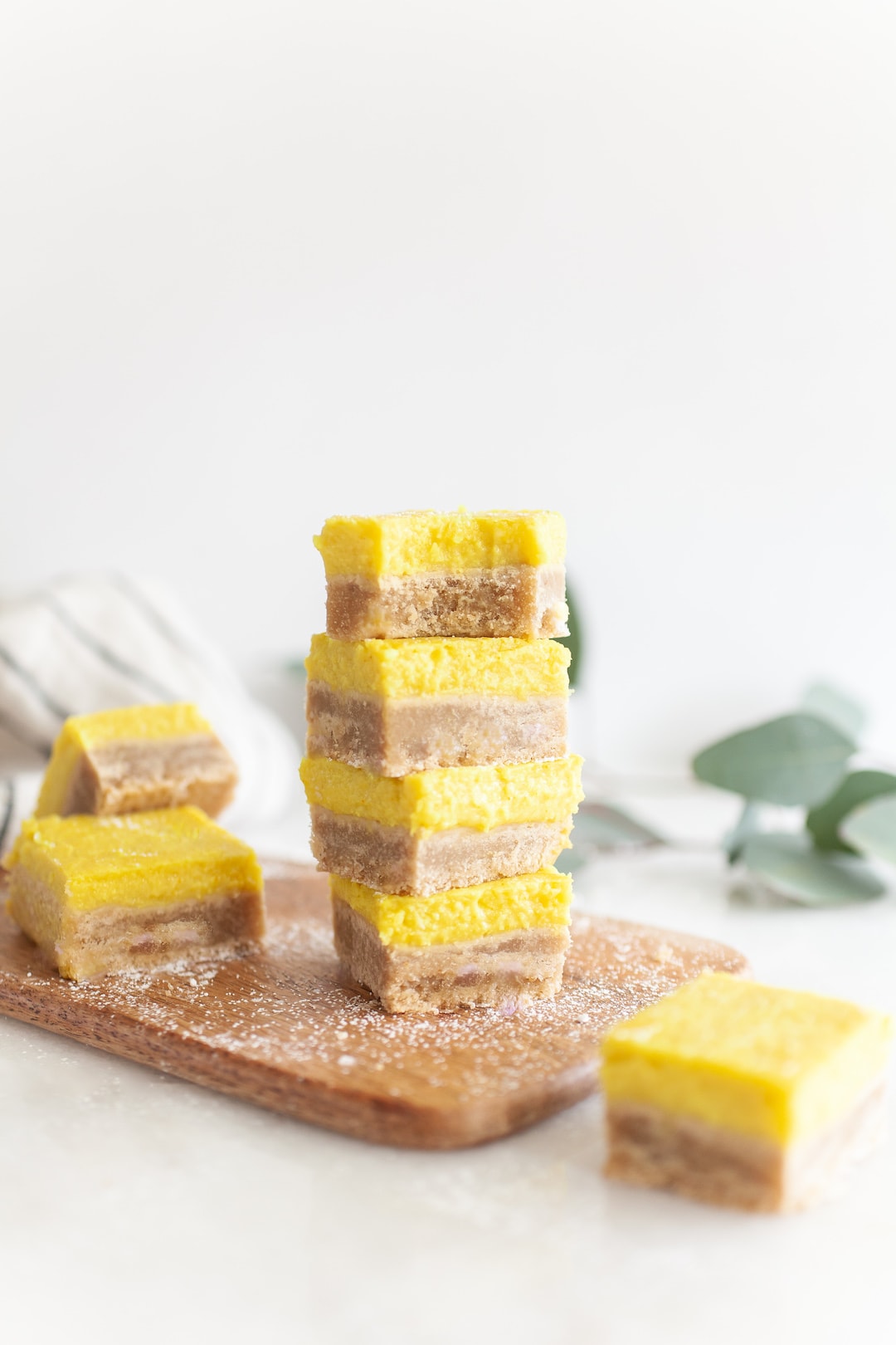 stack of 4 Best Vegan Lemon Bars with bite taken out of the top one