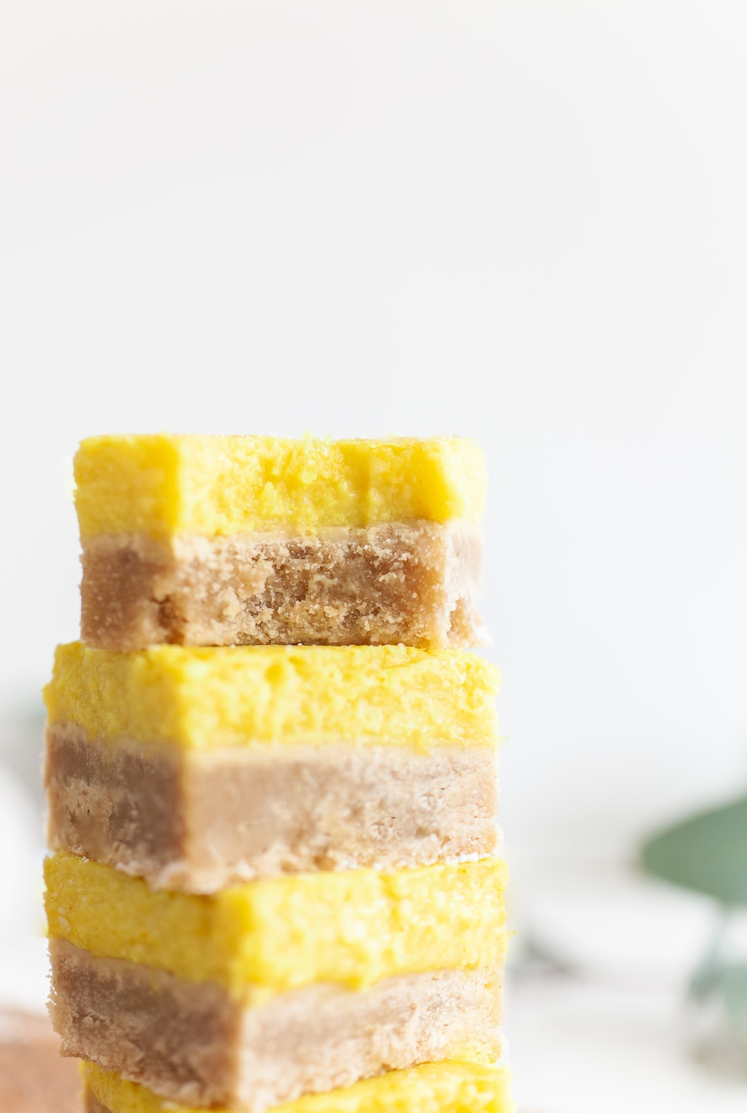 stack of Best Vegan Lemon Bars with bite taken out of top one