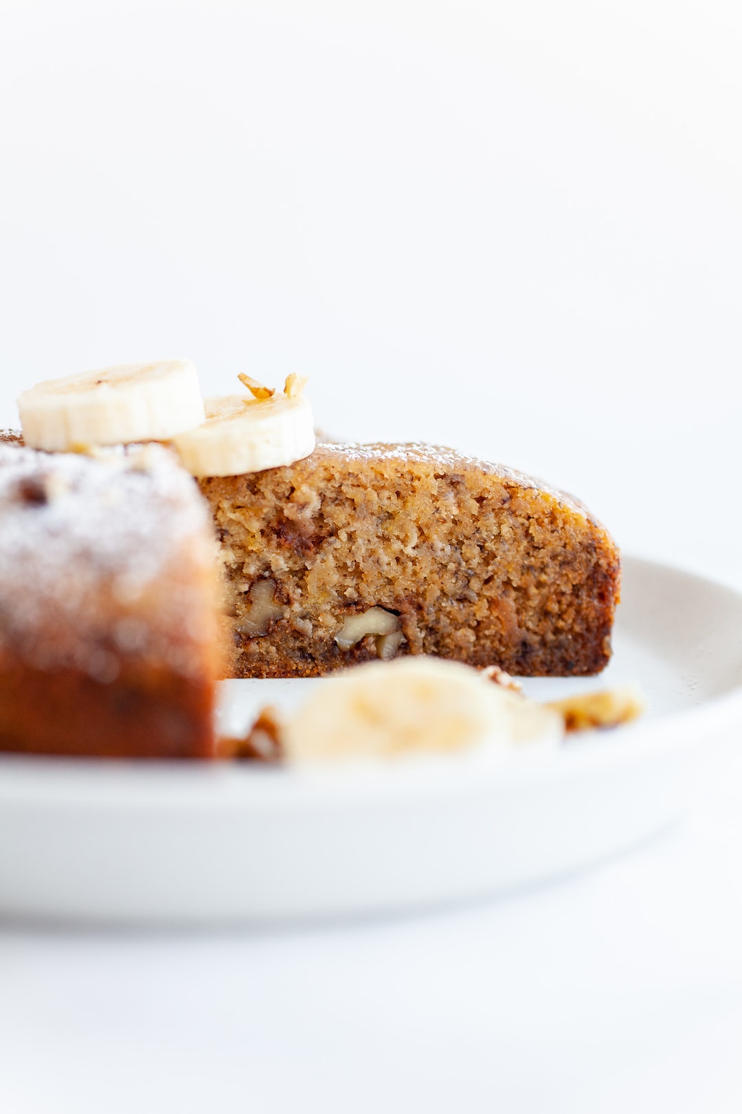 Side view of a loaf of instant pot banana bread with a slice cut out of it