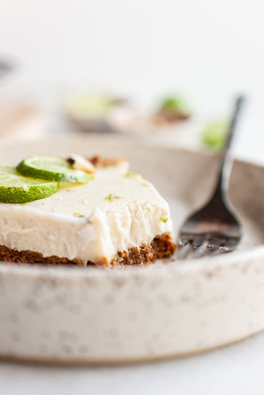 Vegan Key Lime Pie slice up close from the side with a bite taken out