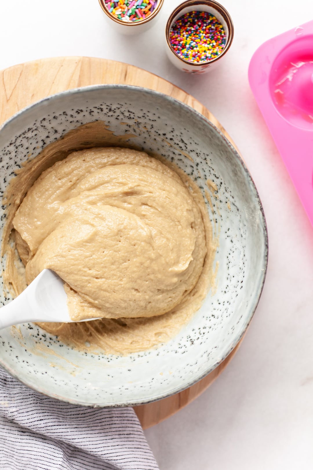 mixed batter for simple vanilla protein donuts in a large mixing bowl with a white spatula