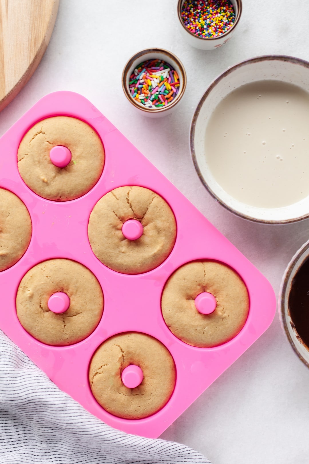 baked simple vanilla protein donuts in a pink silicone donut mould