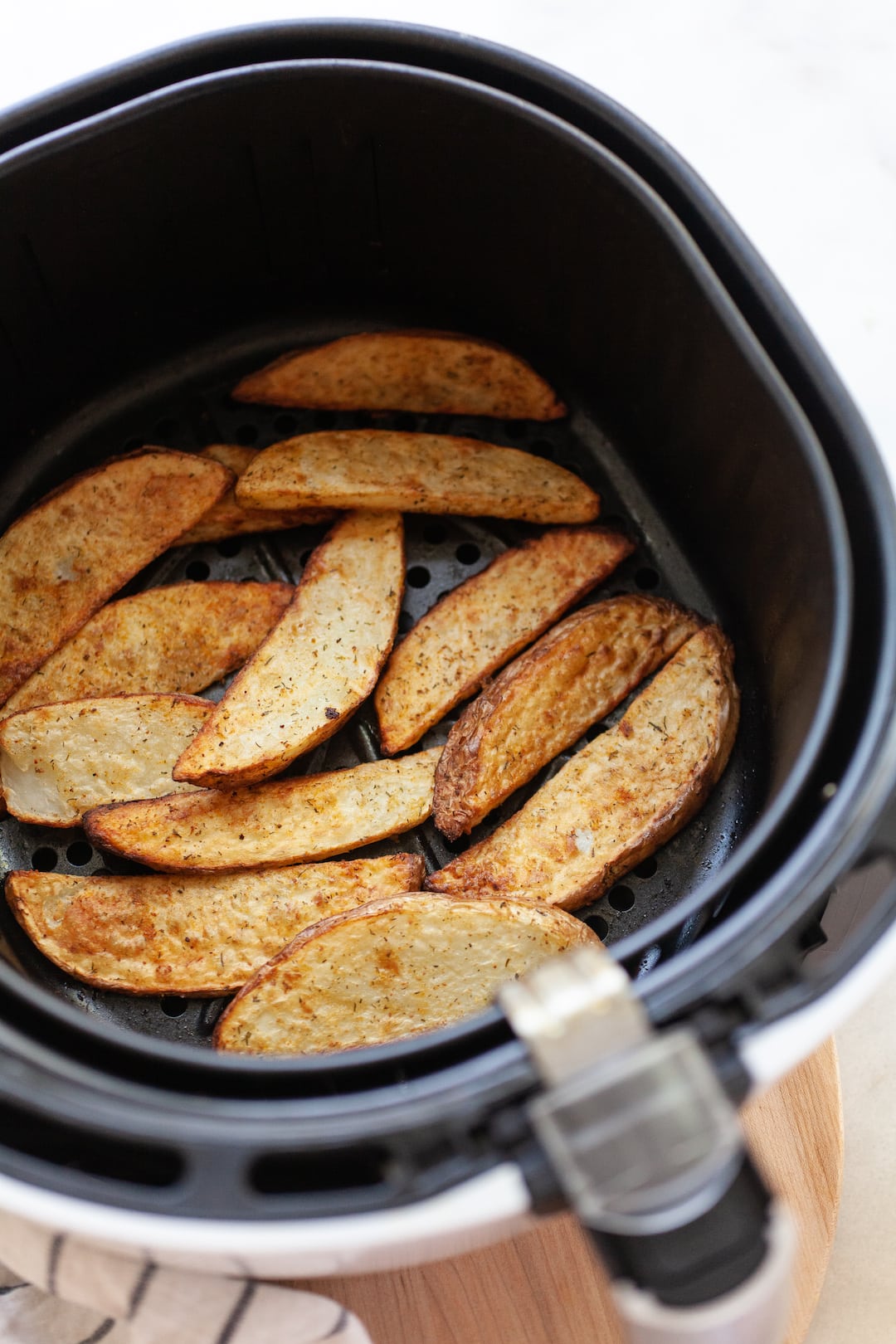 air fried potato wedges in an air fryer basket