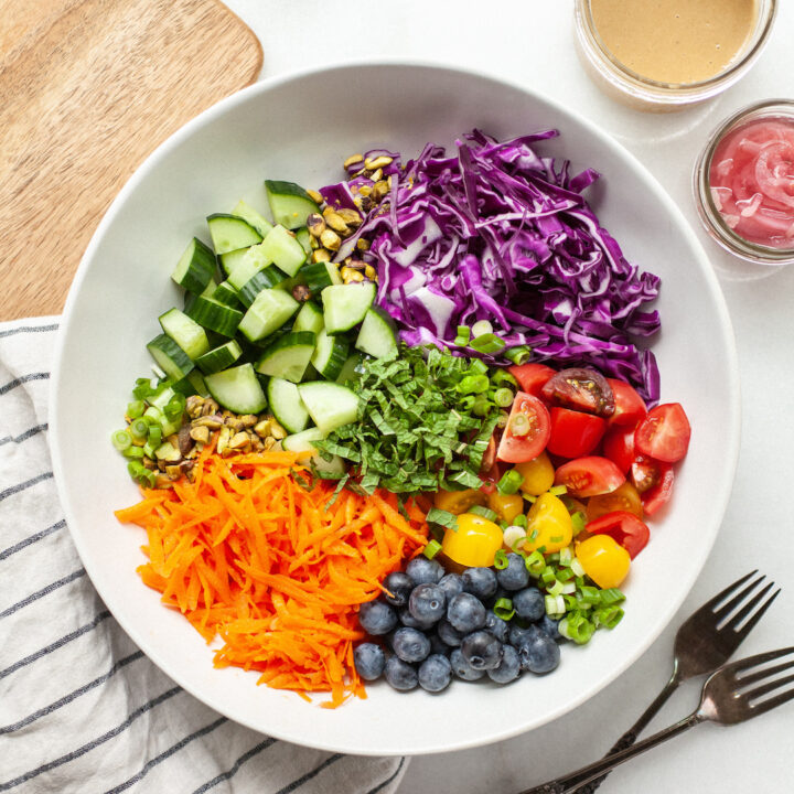 bowl of colourful vegetables including cabbage, cucumber, carrots, and tomatoes