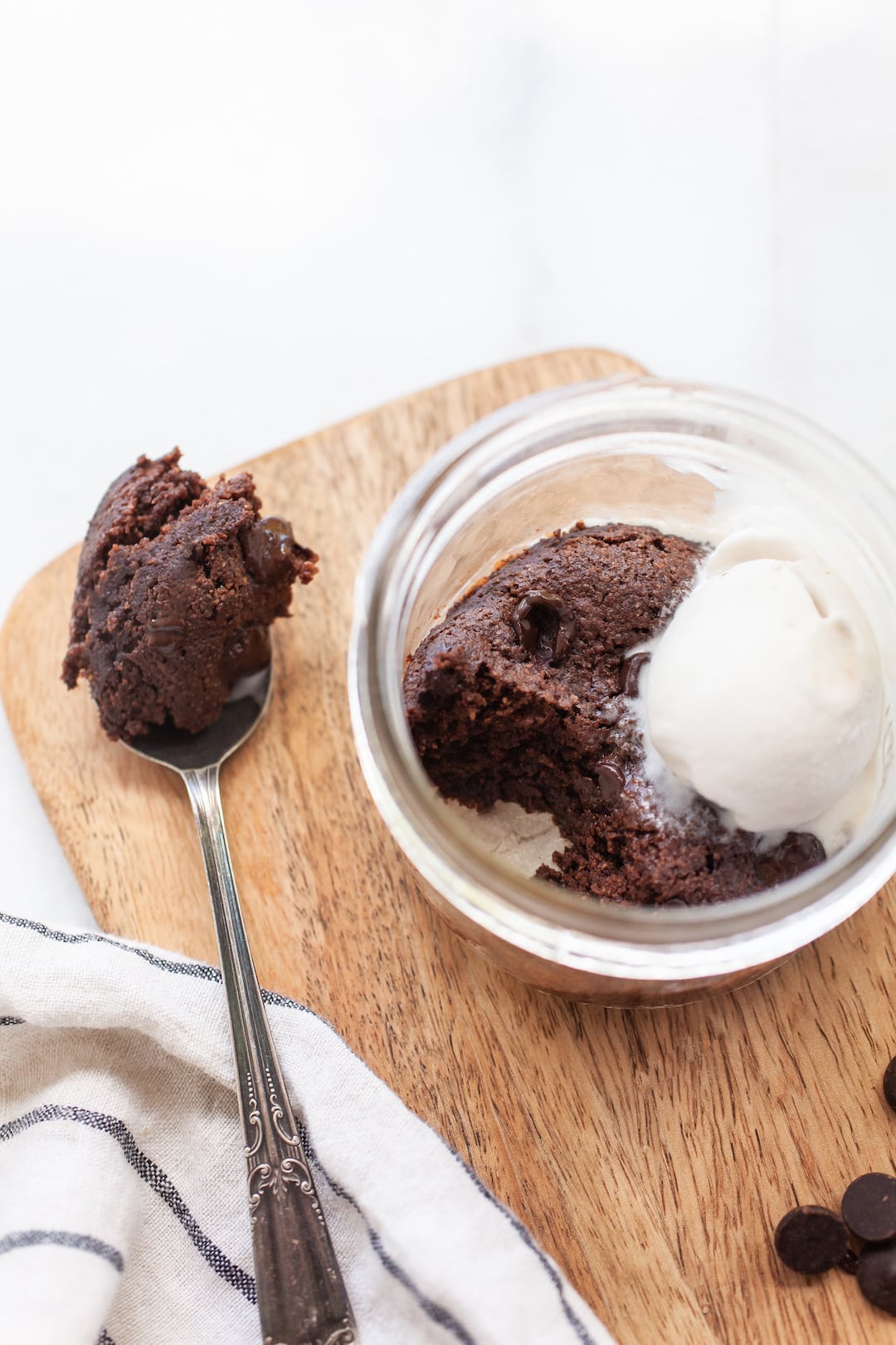 vegan mug brownie in a jar with a scoop taken out with a spoon sitting on the side