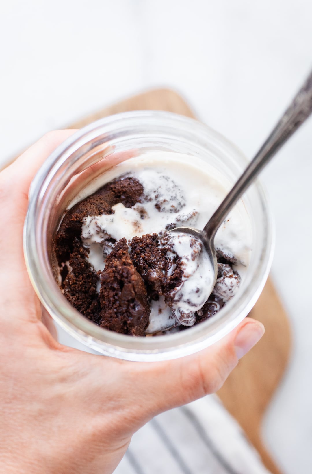 mug brownie in a jar with a spoon and vanilla vegan ice cream