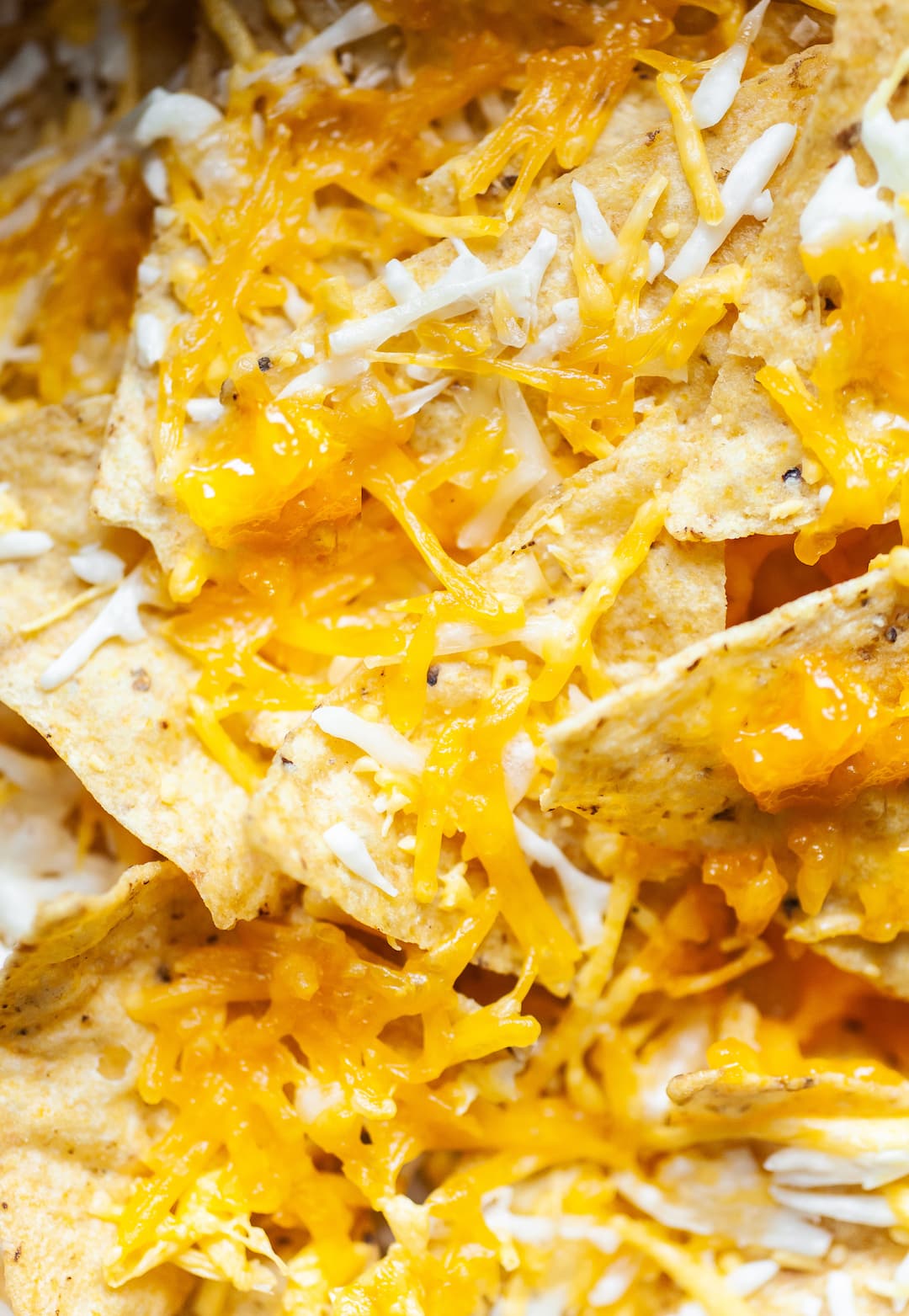 Close up of air fryer nachos - tortilla chips with melted cheese