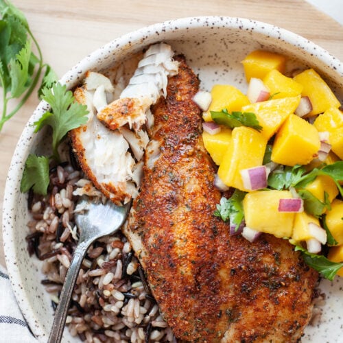 Plate of Air Fryer Tilapia on a bed of wild rice with mango salsa