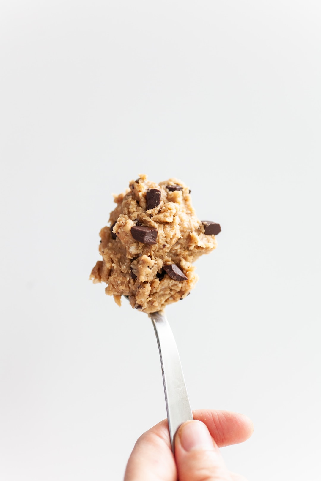 spoon of protein cookie dough on a white background