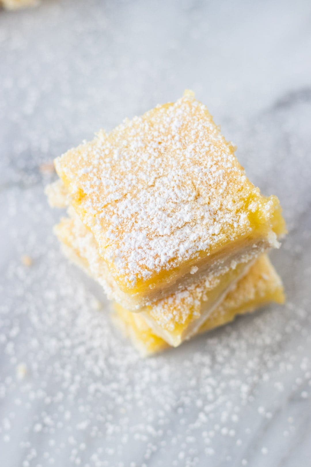 stack of low fodmap lemon bars topped with powdered sugar