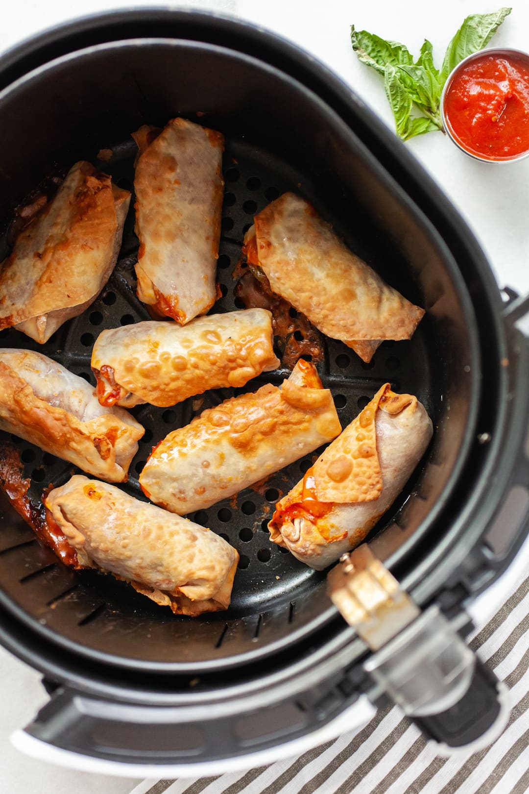 image of cooked air fryer pizza rolls in an air fryer basket