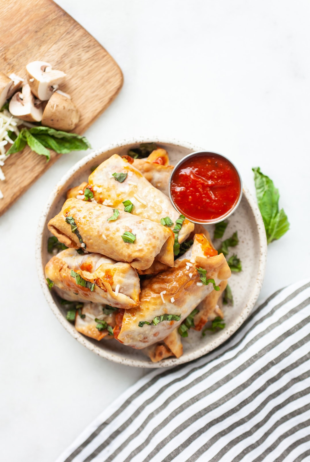 image of air fryer pizza rolls on a plate with pizza sauce on the side