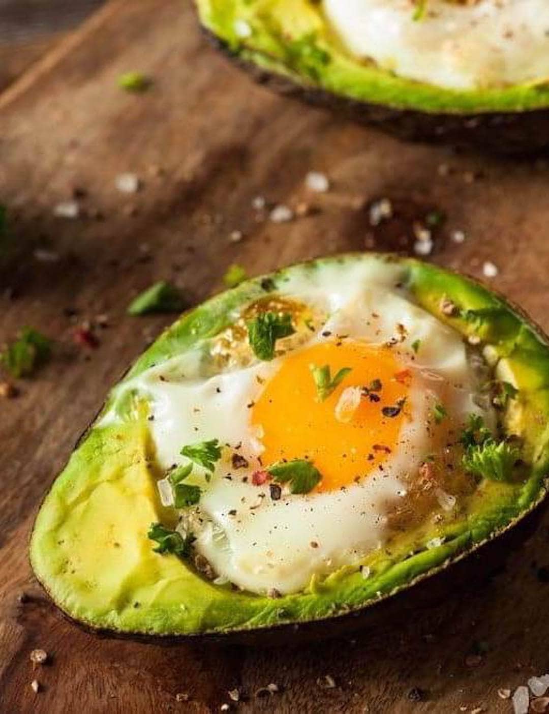 image of an air fryer avocado with egg on a wood platter