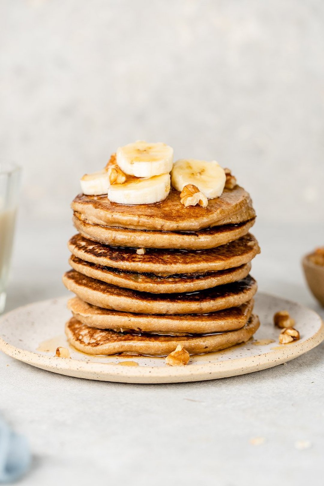 image of 3-ingredient low fodmap pancakes in a stack topped with banana slices
