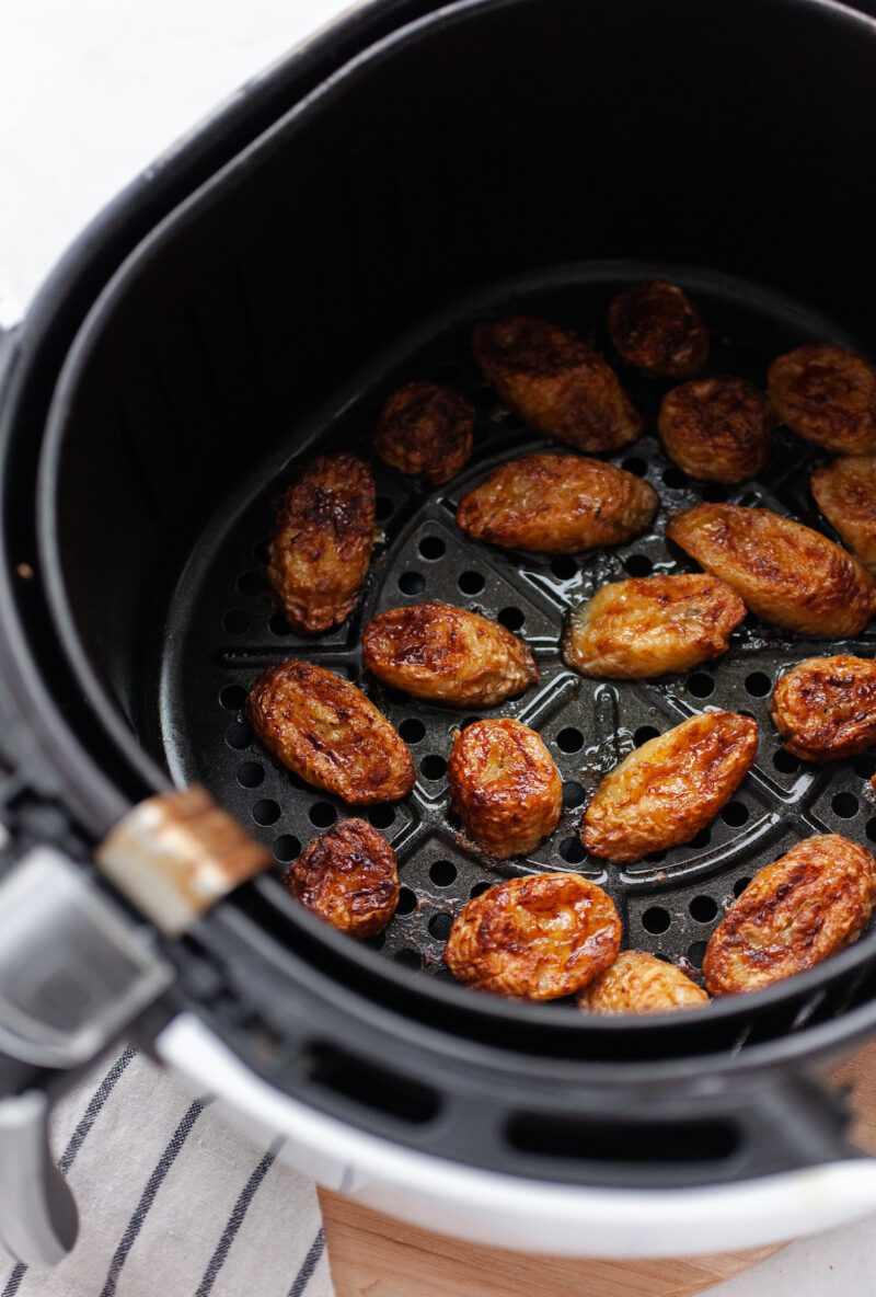 image of an air fryer with caramelized banana slices inside